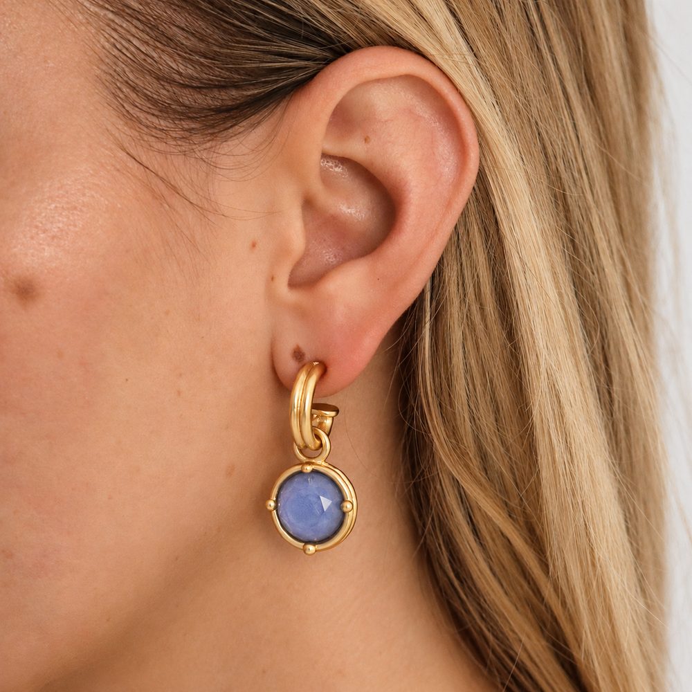 model wearring small gold hoop with blue gem charm earrings