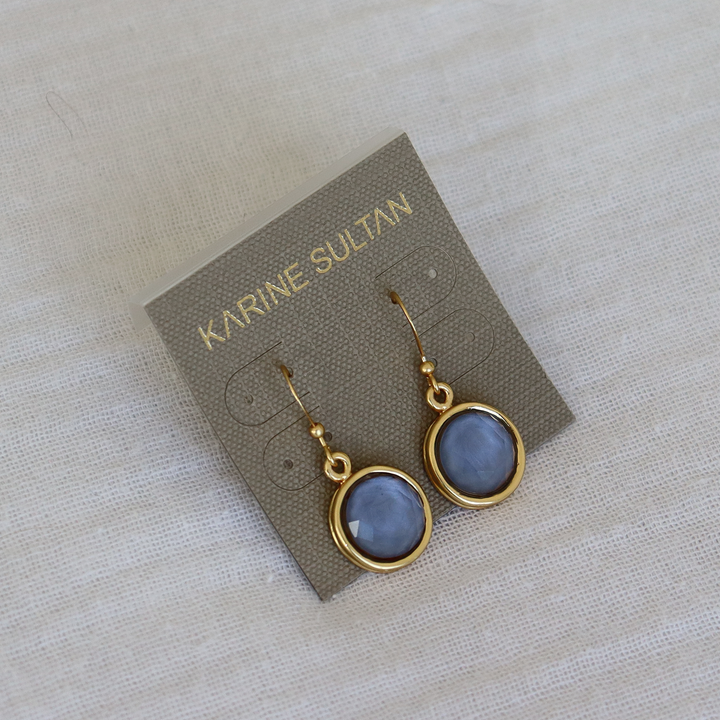 Soft Denim Blue Cabochon Dangle Earrings displayed on branded card and neutral fabric