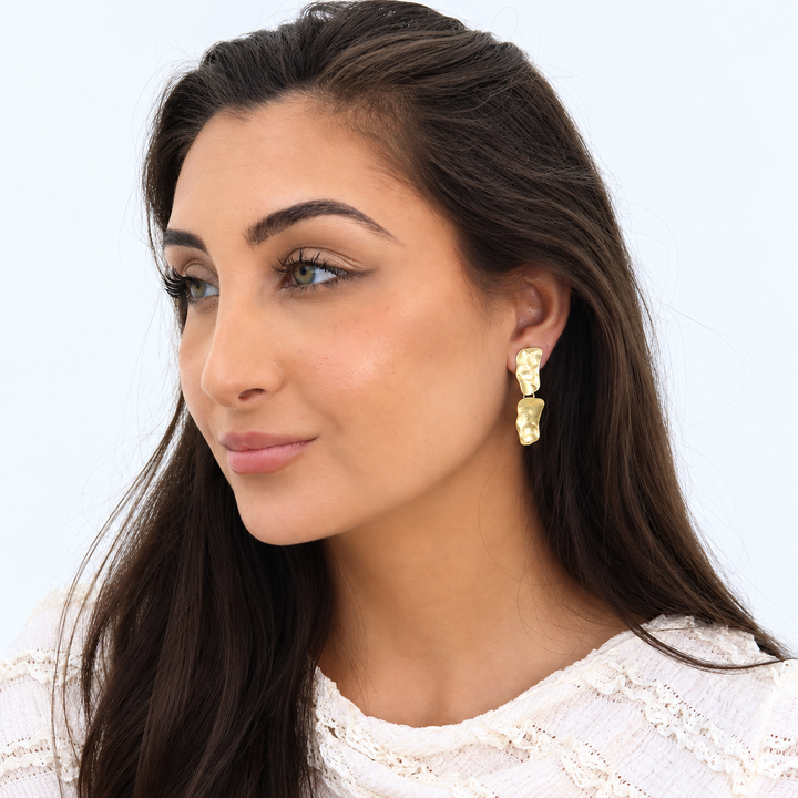 Gold Cobblestone Drop Clip-On Earring worn on brunette model showing hammered dangling links