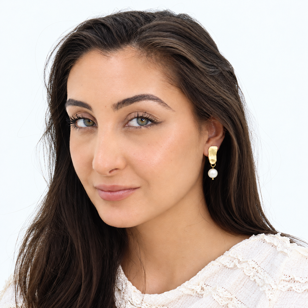 Gold Cobblestone Pearl Clip-On Earring worn on brunette model with white textured blouse