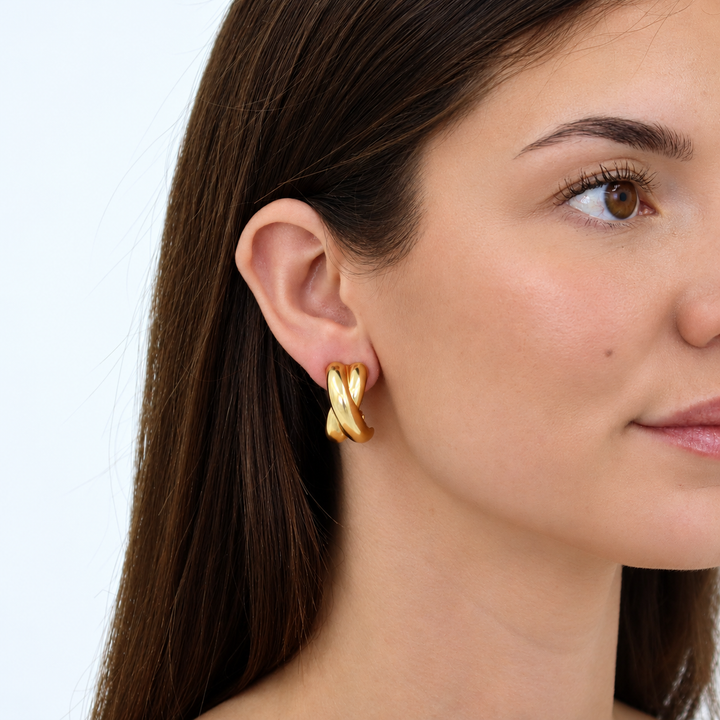 Criss Cross Clip-On Hoop Earring worn on brunette model showing sculpted gold crossover design