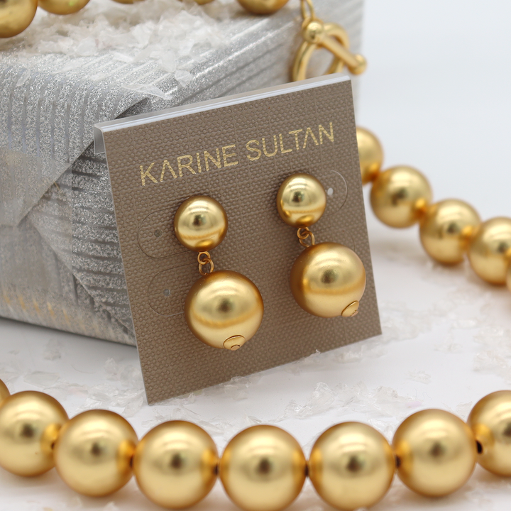 Golden Sphere Drop Earrings on Karine Sultan jewelry card beside gold plated beaded necklace