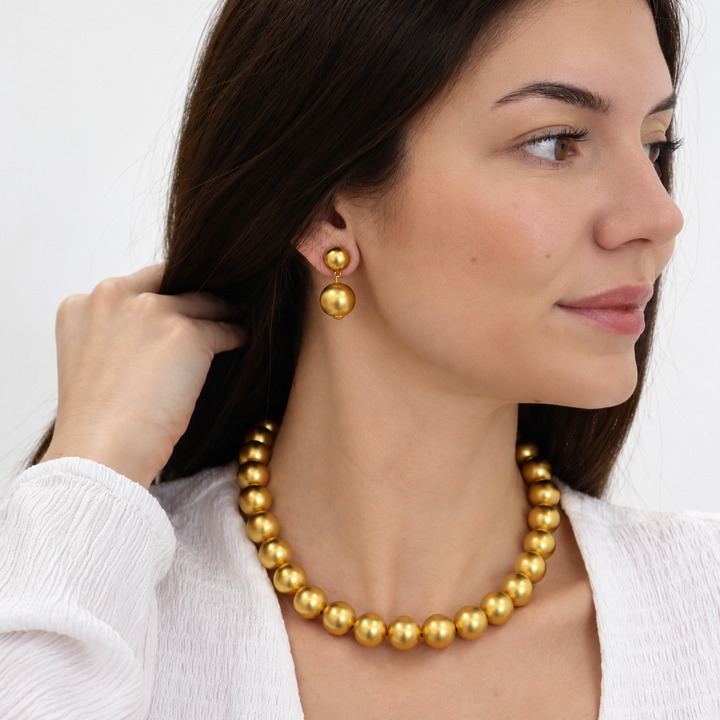 Golden Sphere Drop Earrings worn with coordinating gold plated sphere necklace and white blouse