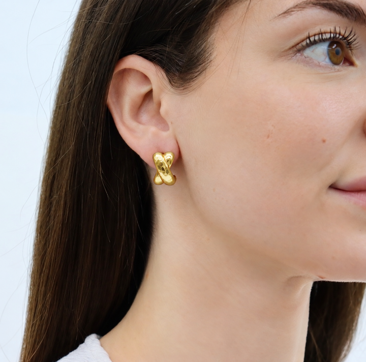 Hammered Cross Stud Earrings worn on model showing softly hammered sculptural design