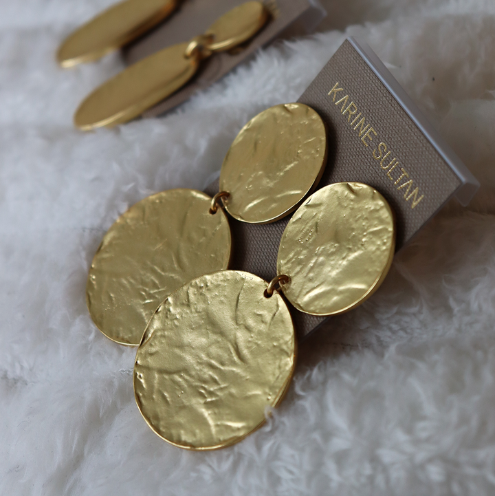 Gold Hammered Disc Statement Earrings displayed on Karine Sultan card over soft white fabric