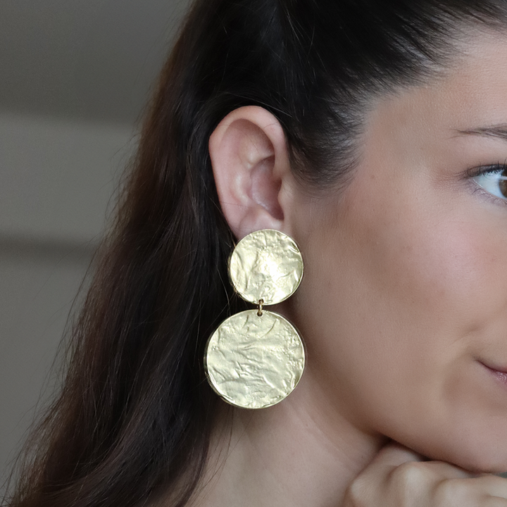 Gold Hammered Discs Clip-On Earring worn close up showing two irregular reflective discs