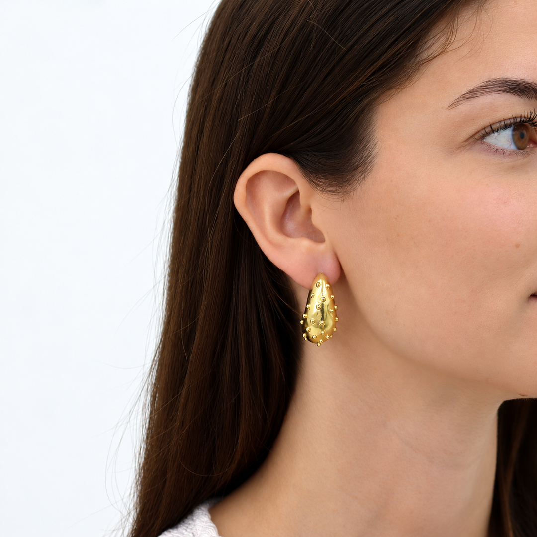 Ladybug Hoop Earrings worn on brunette model showing gold plated dotted surface
