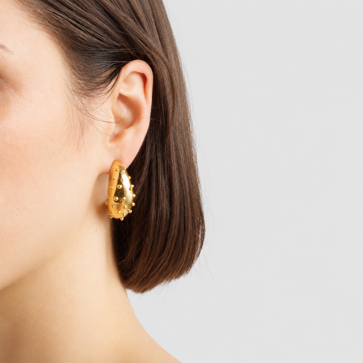 Ladybug Hoop Earrings worn on model showing raised dotted details and curved shape