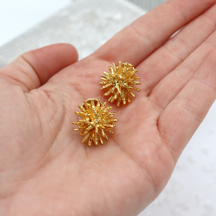 Mini Starburst Stud Earrings resting in hand showing compact size and textured rays