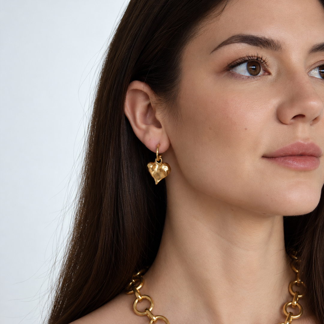 Molten Heart Drop Earrings worn on brunette model showing dangling gold plated heart
