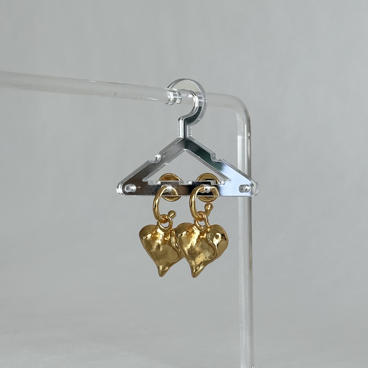 Molten Heart Drop Earrings displayed on miniature transparent hanger showing dangling heart charms