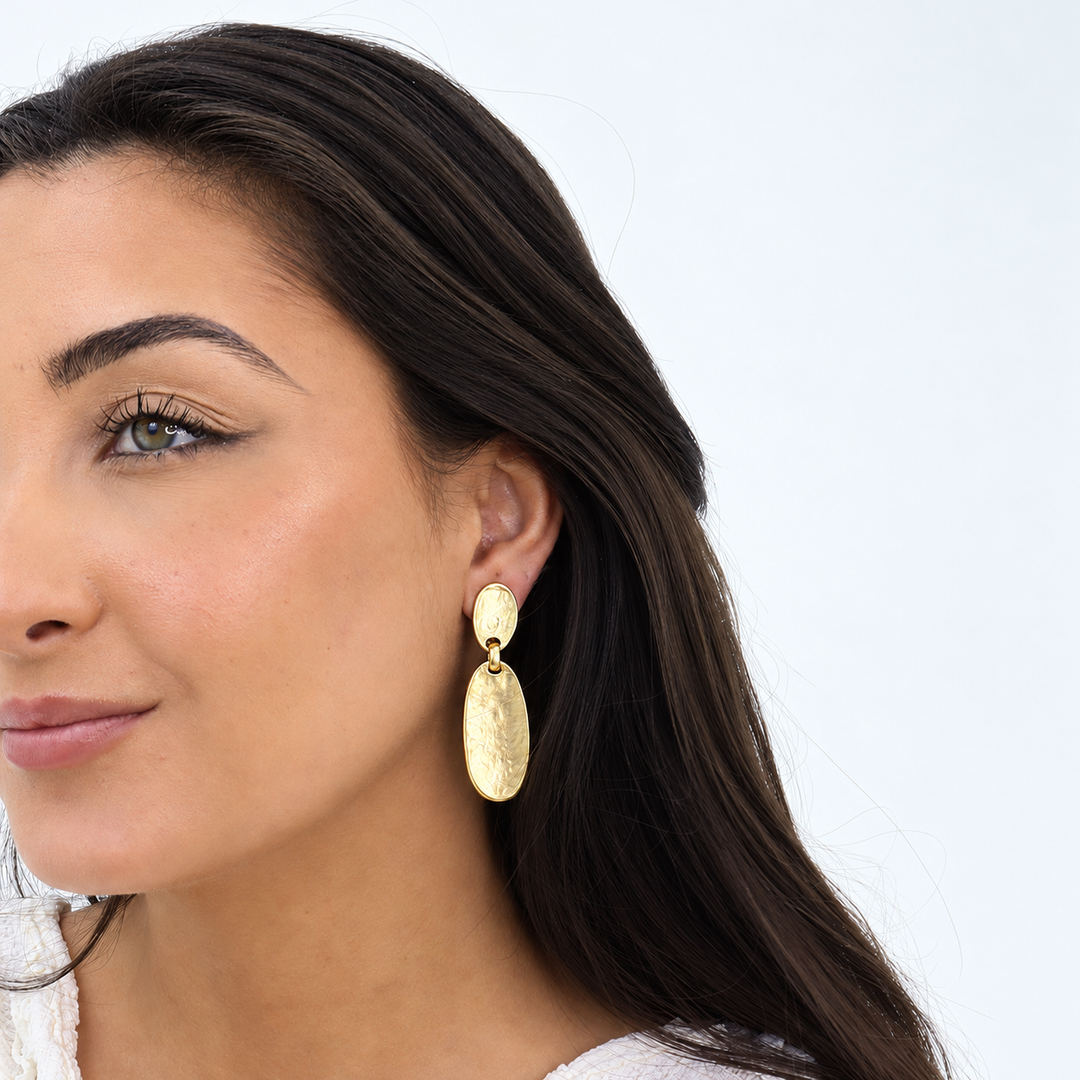 Gold Oval Plate Clip-On Earring worn on brunette model showing two elongated hammered ovals