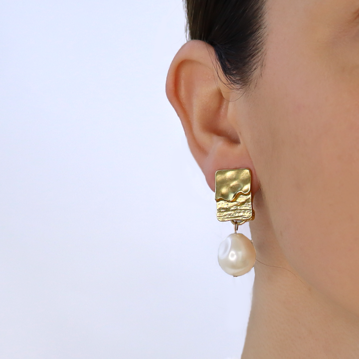 Gold Pearl Drop Clip-On Earring worn close up showing contrasting metal textures and dangling pearl