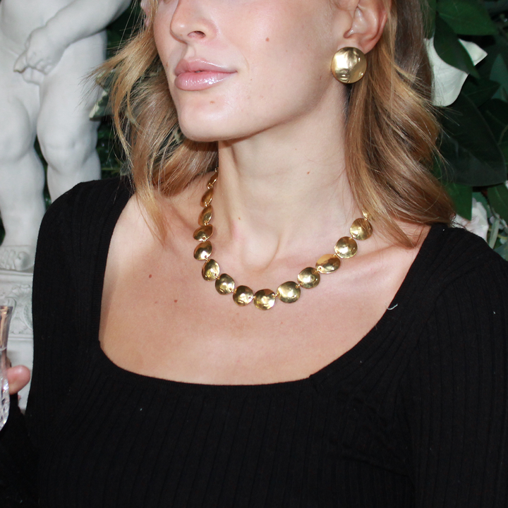 Gold Shell Disc Clip-On Earrings styled with matching hammered disc necklace
