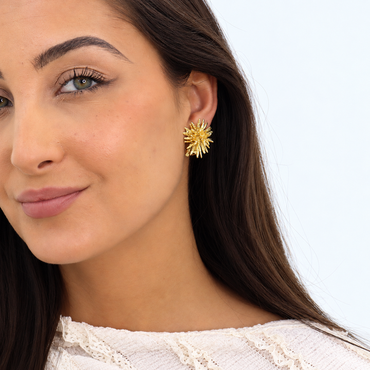 Gold Starburst Clip-On Earring worn close up showing sculpted coral-like textured rays