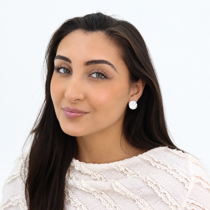 Silver Textured Coin Clip-On Earrings worn on brunette model with white lace blouse