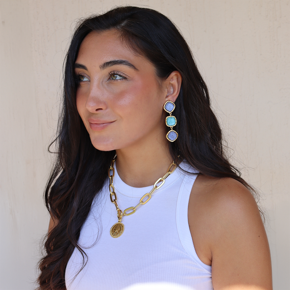 a women wearings statement earrings featuring three blue stones, clip on earrings by jewwelry designer karine sultan