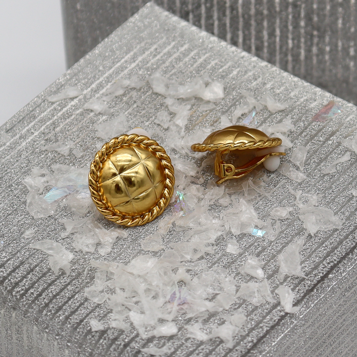 Tufted Texture Clip-On Earrings displayed on silver surface showing rope borders and padded closures