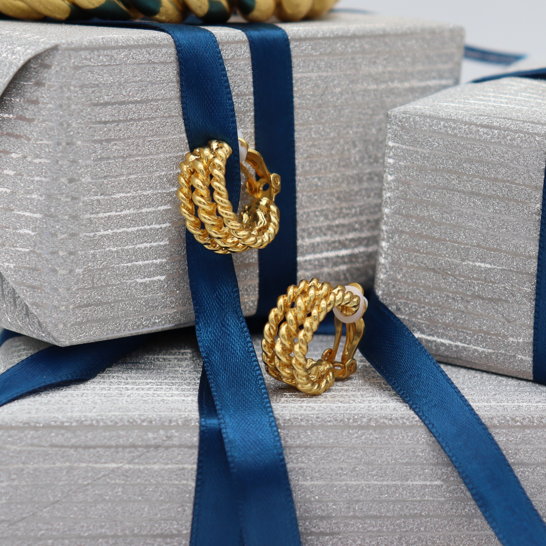 Twisted Rope Clip-On Hoop Earrings displayed on silver gift boxes with blue satin ribbon