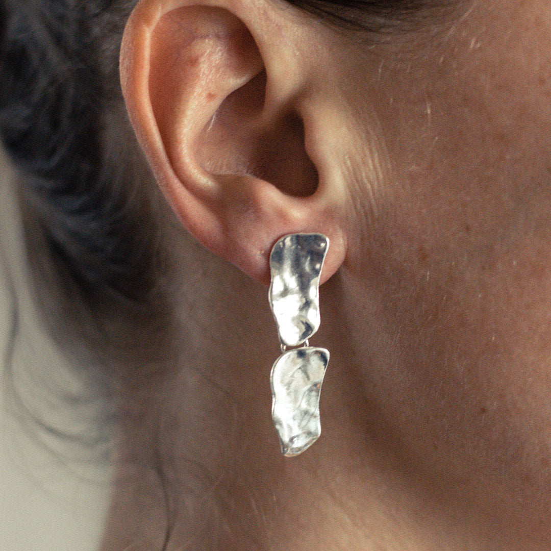 Silver Cobblestone Drop Earring worn close up showing two polished irregular hanging plates