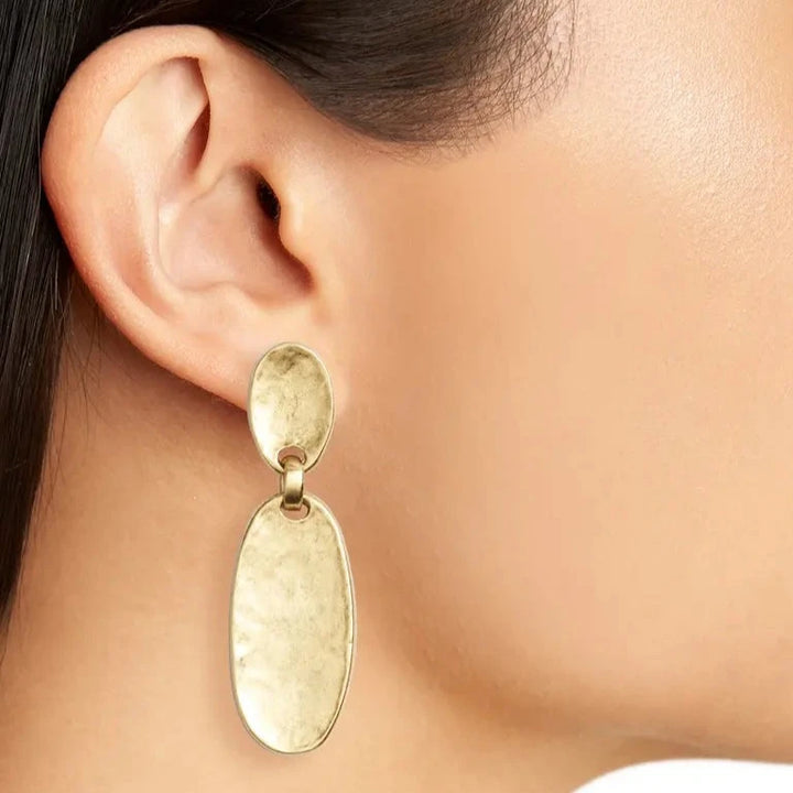 Gold Oval Plate Clip-On Earring worn close up showing softly hammered metal texture