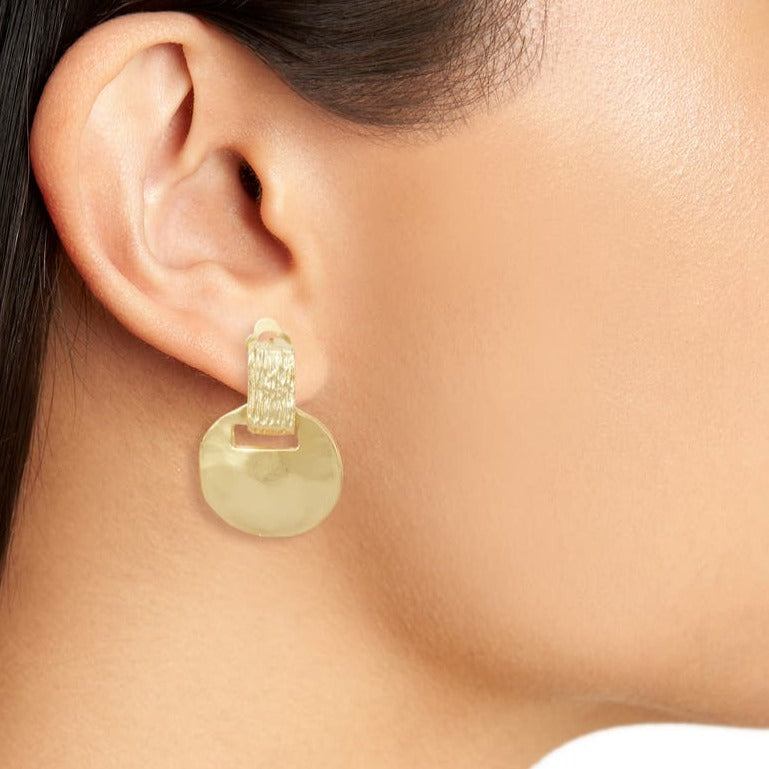Gold Short Drop Clip-On Earring worn on brunette model showing textured top and hammered disc